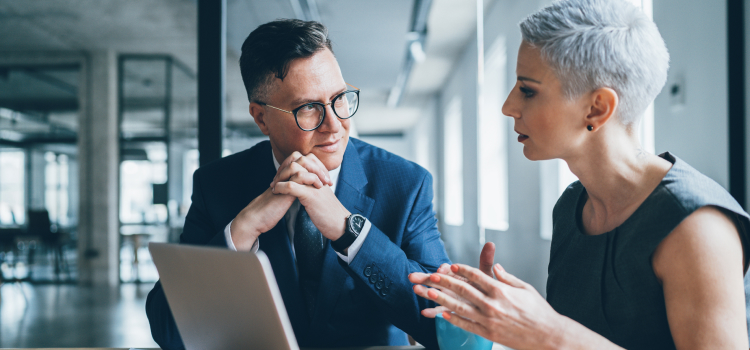 Image d’un homme et d’une femme qui discutent dans un bureau