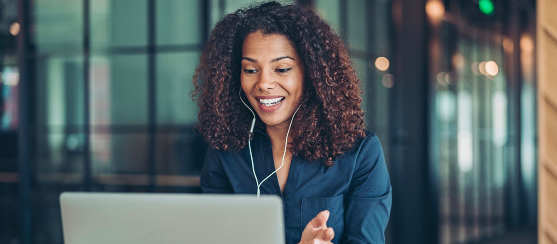 Photo d'une femme portant des écouteurs tout en parlant lors d'une réunion virtuelle