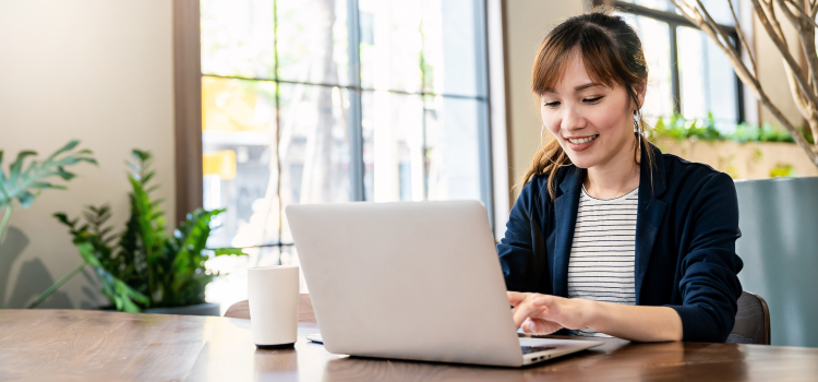 Image d'une femme souriante devant son ordinateur portable